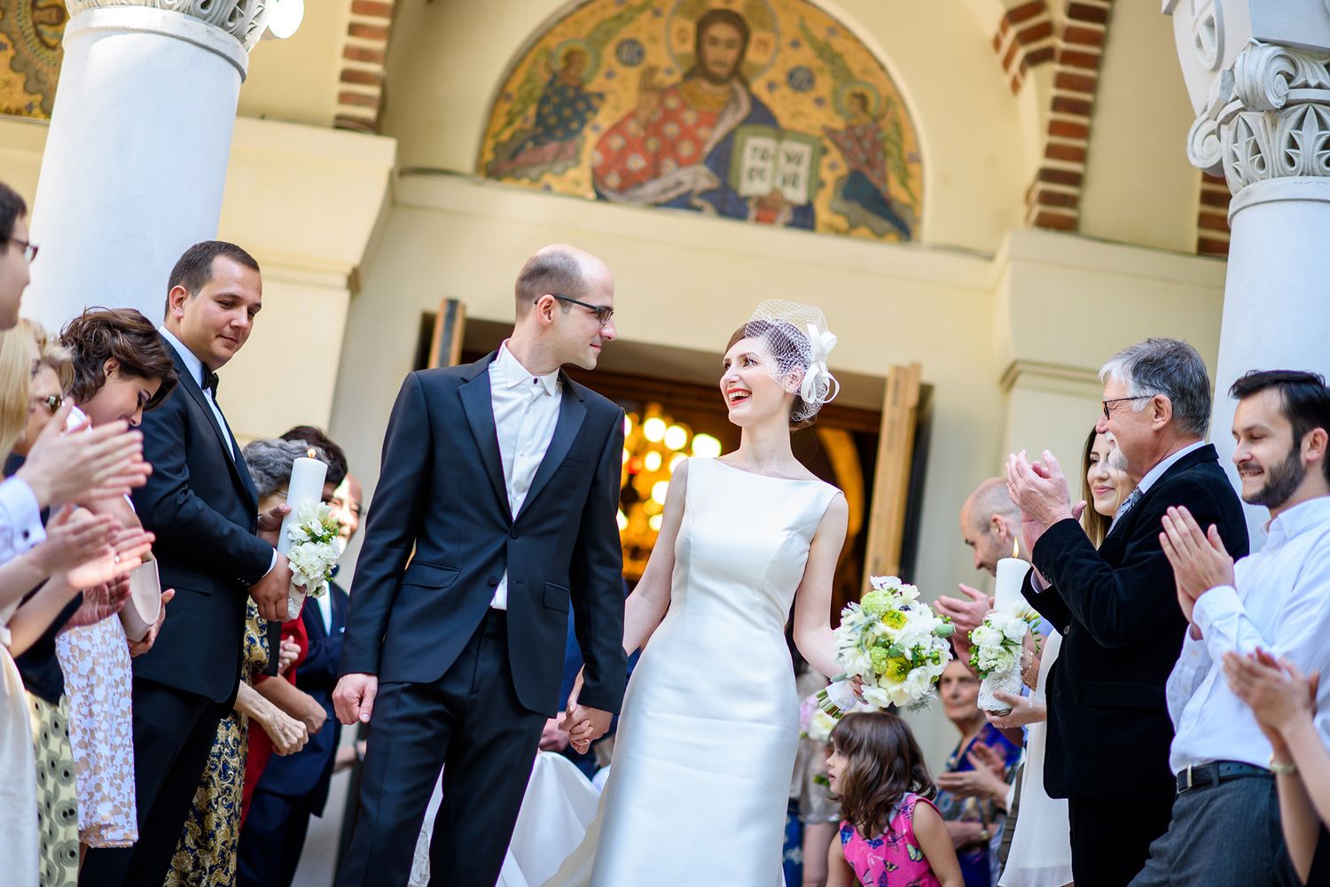 Elegant wedding ceremony taking place in a grand historic building with decorative columns and artwork.
