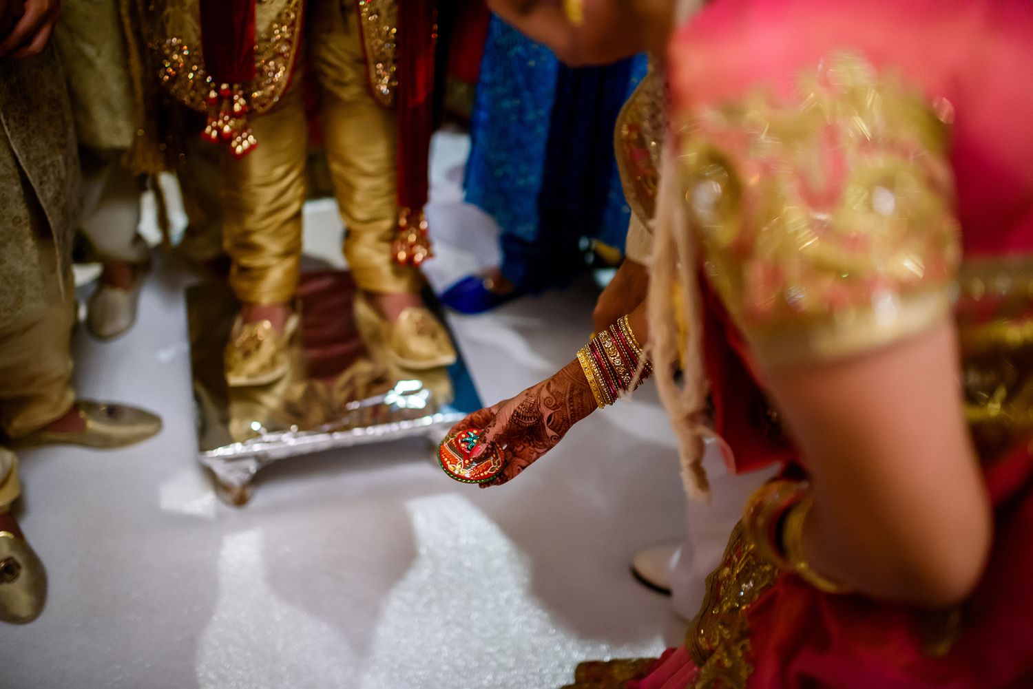 Detail shot of traditional gold and pink Indian wedding attire and decorations.