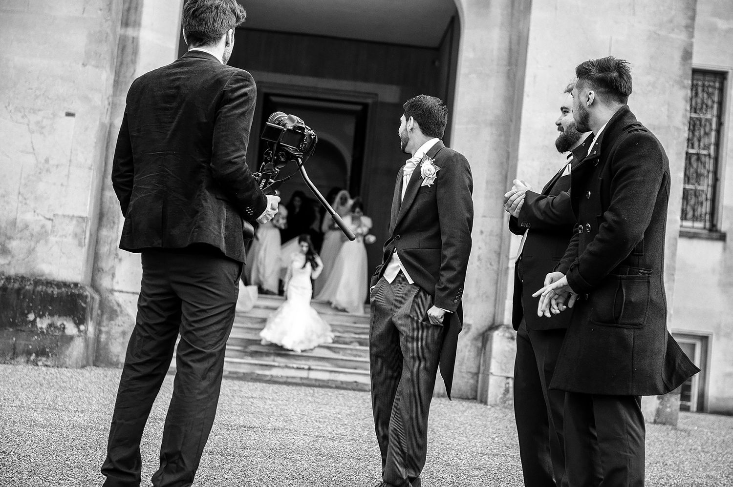 Black and white photo of musicians performing outside venue during wedding.