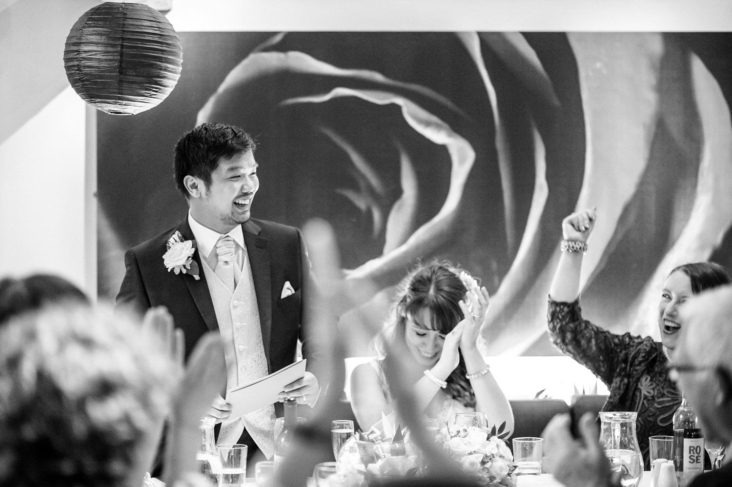Black and white panoramic view of wedding reception with disco ball overhead.