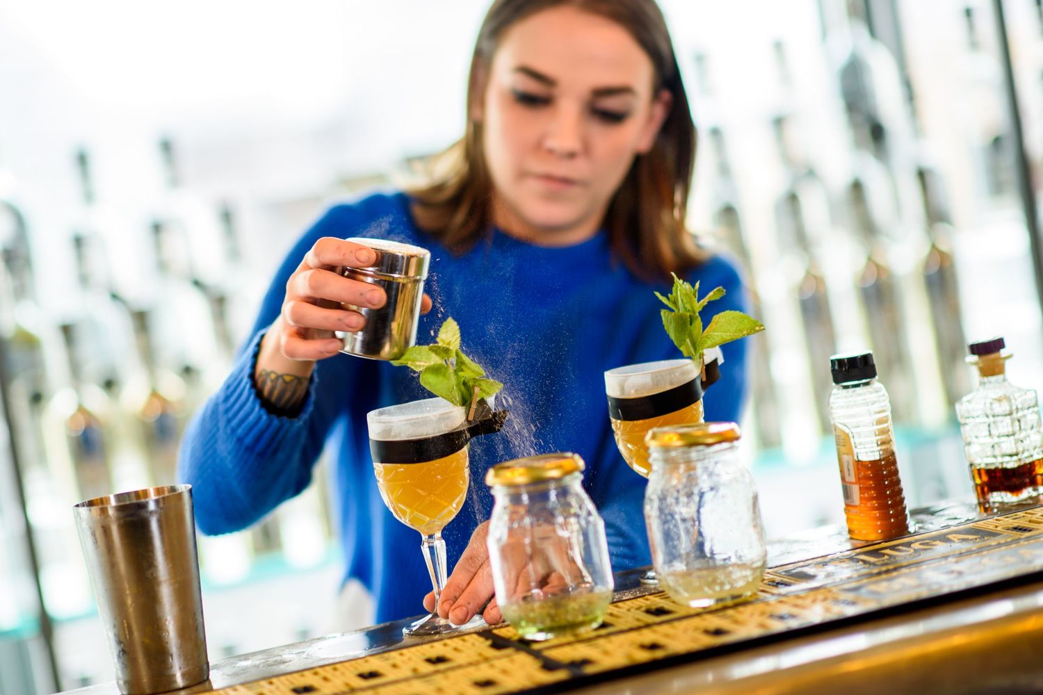 Close-up of craft beer tasting flight with various beverages on wooden bar.