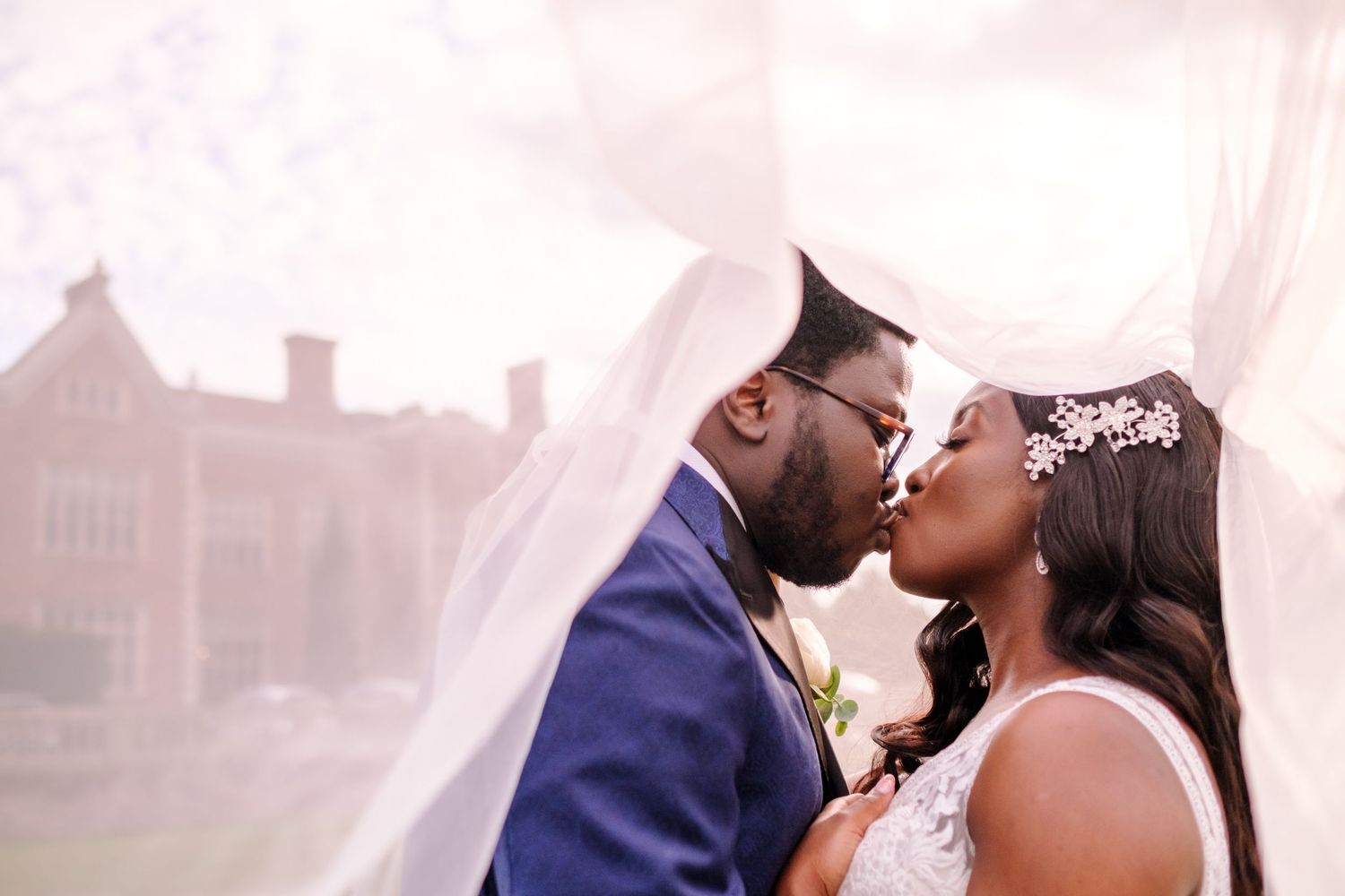 A couple shares a romantic dance moment on an elegant white dance floor at a formal celebration.
