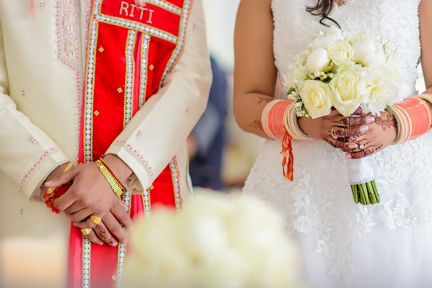 Wedding ceremony details featuring white bouquet and red ceremonial ribbons.