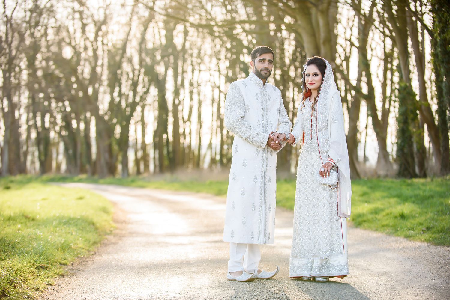 Series of romantic couple portraits taken along a tree-lined path in natural lighting.