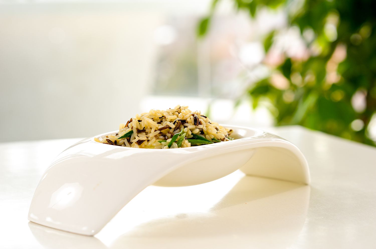 Fresh salad greens and herbs arranged on a white plate with garnishes and dressing.
