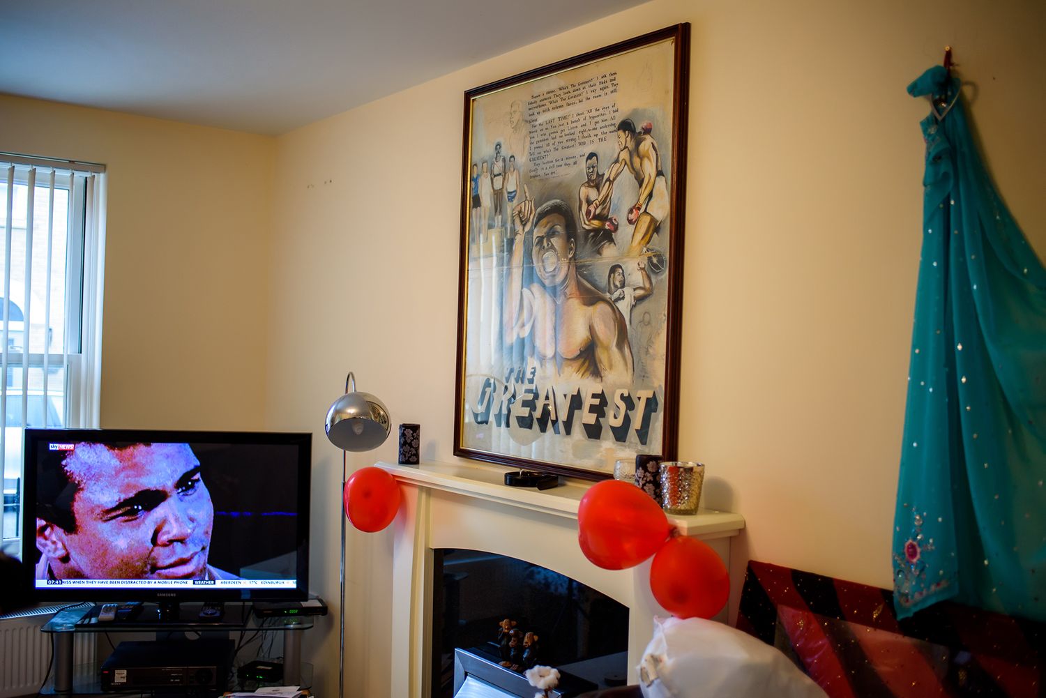 Interior view of a living room with wall art, red balloons, and turquoise curtains.