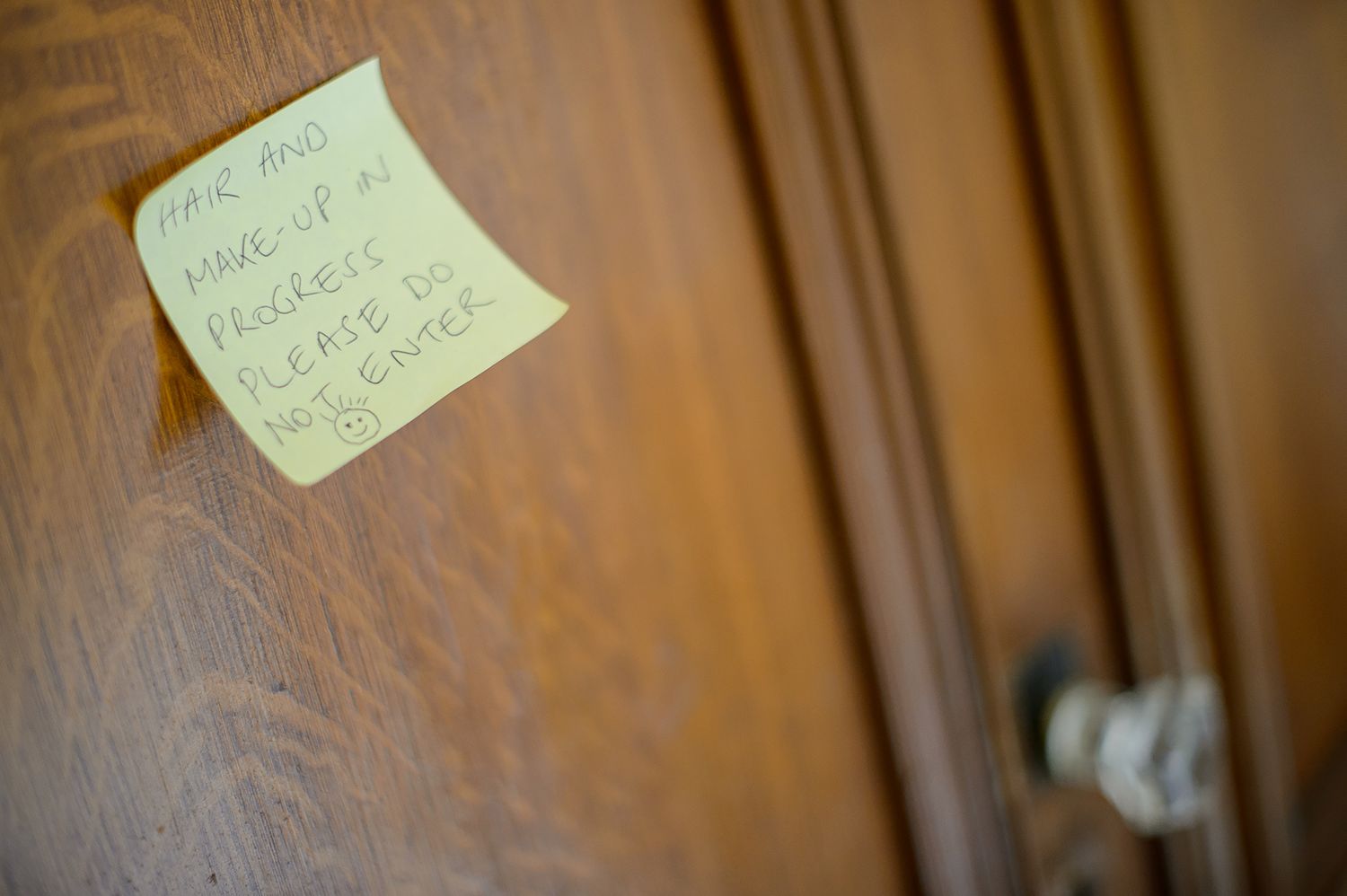 Close-up view of handwritten notes posted on a wooden door surface.