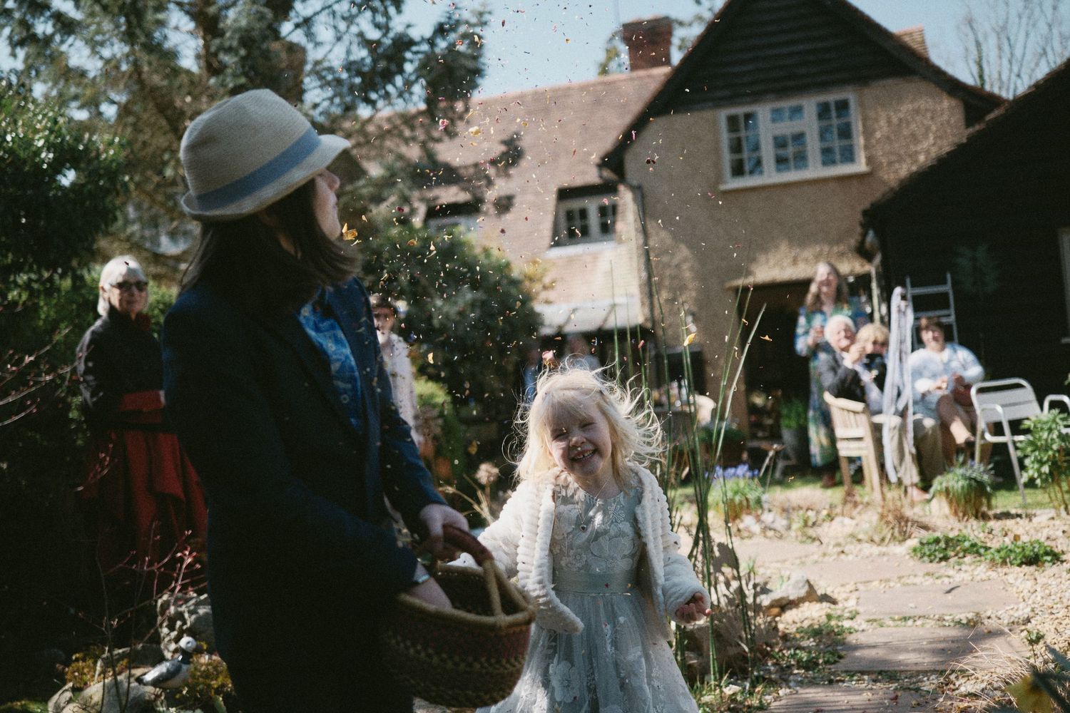 Guests blowing bubbles during an outdoor wedding celebration near a rustic country house.
