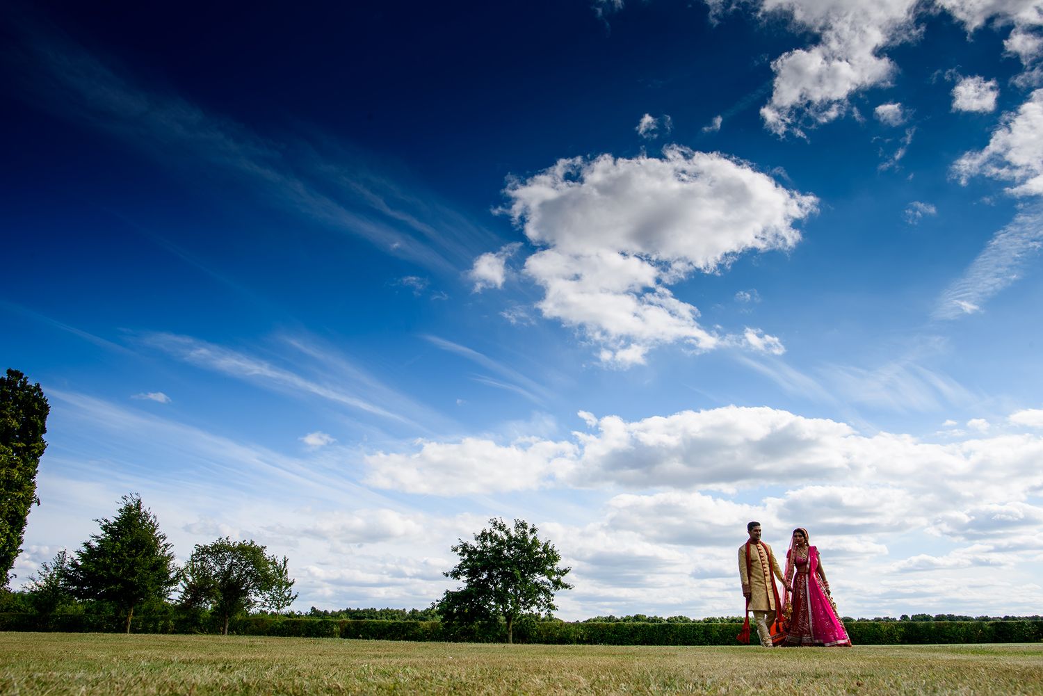 Panoramic landscape view of a wedding venue with blue sky and scattered clouds.