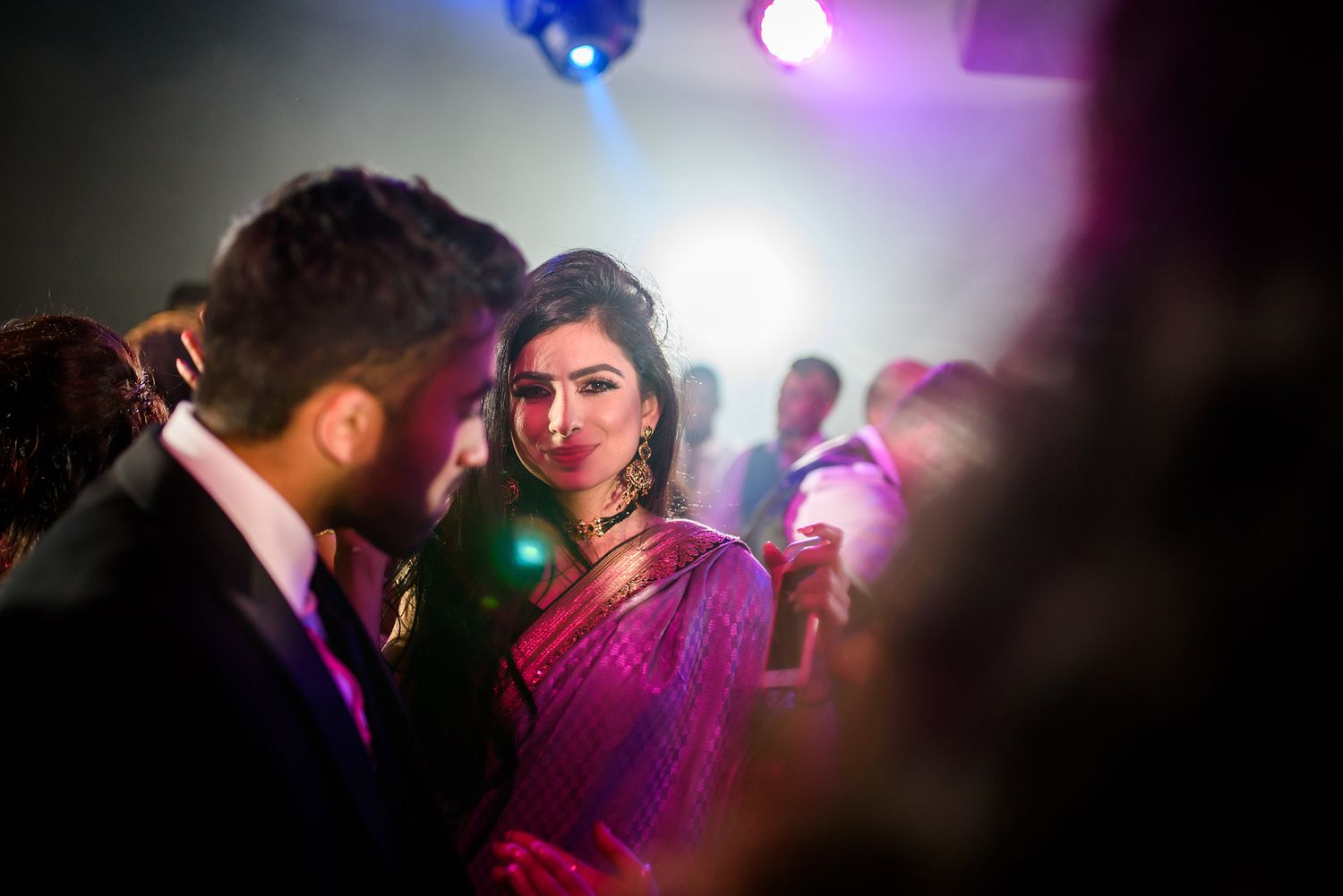 Purple and pink mood lighting creates atmosphere at an evening reception party.