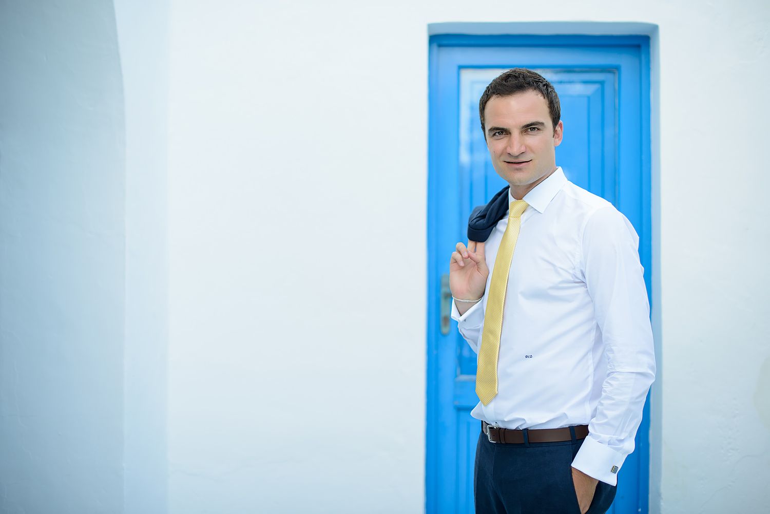 Clean white walls with bright blue door creating Mediterranean aesthetics.