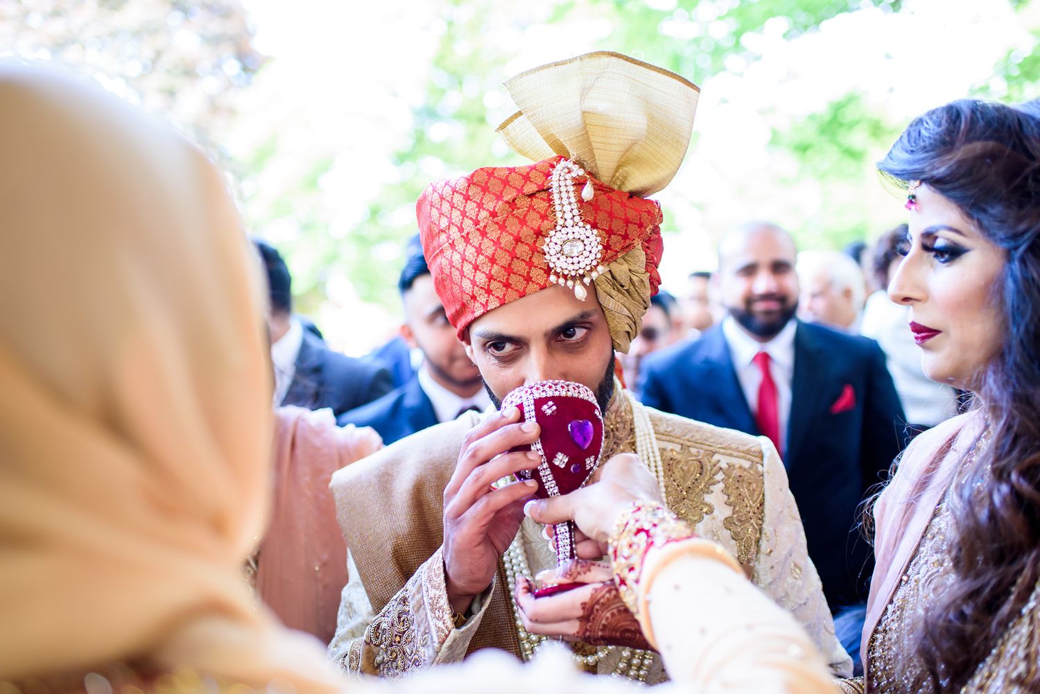 Festive crowd enjoying a vibrant Indian wedding celebration with colorful traditional attire and decorations.