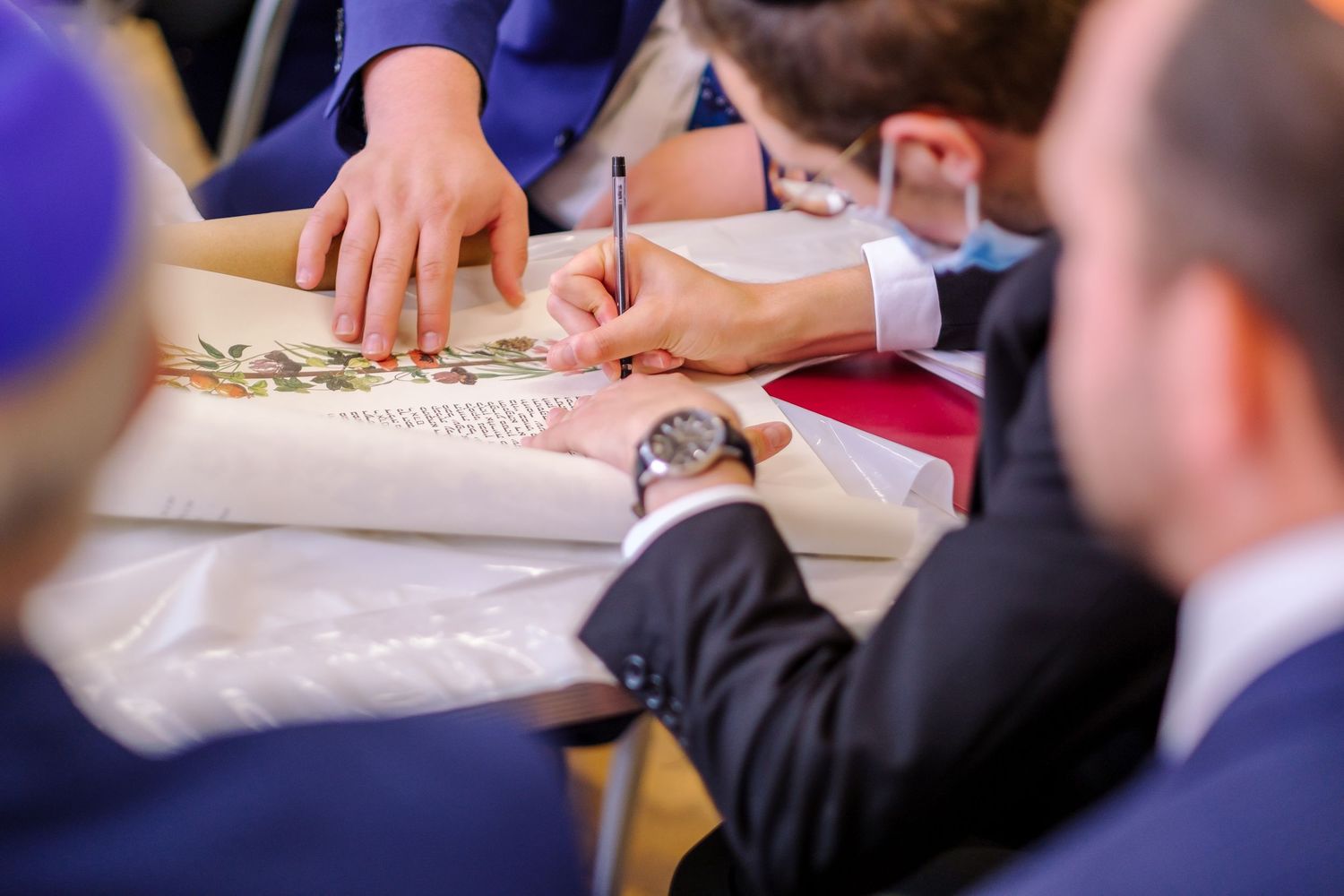 Close-up view of hands writing and taking notes on paper during a business meeting or conference.
