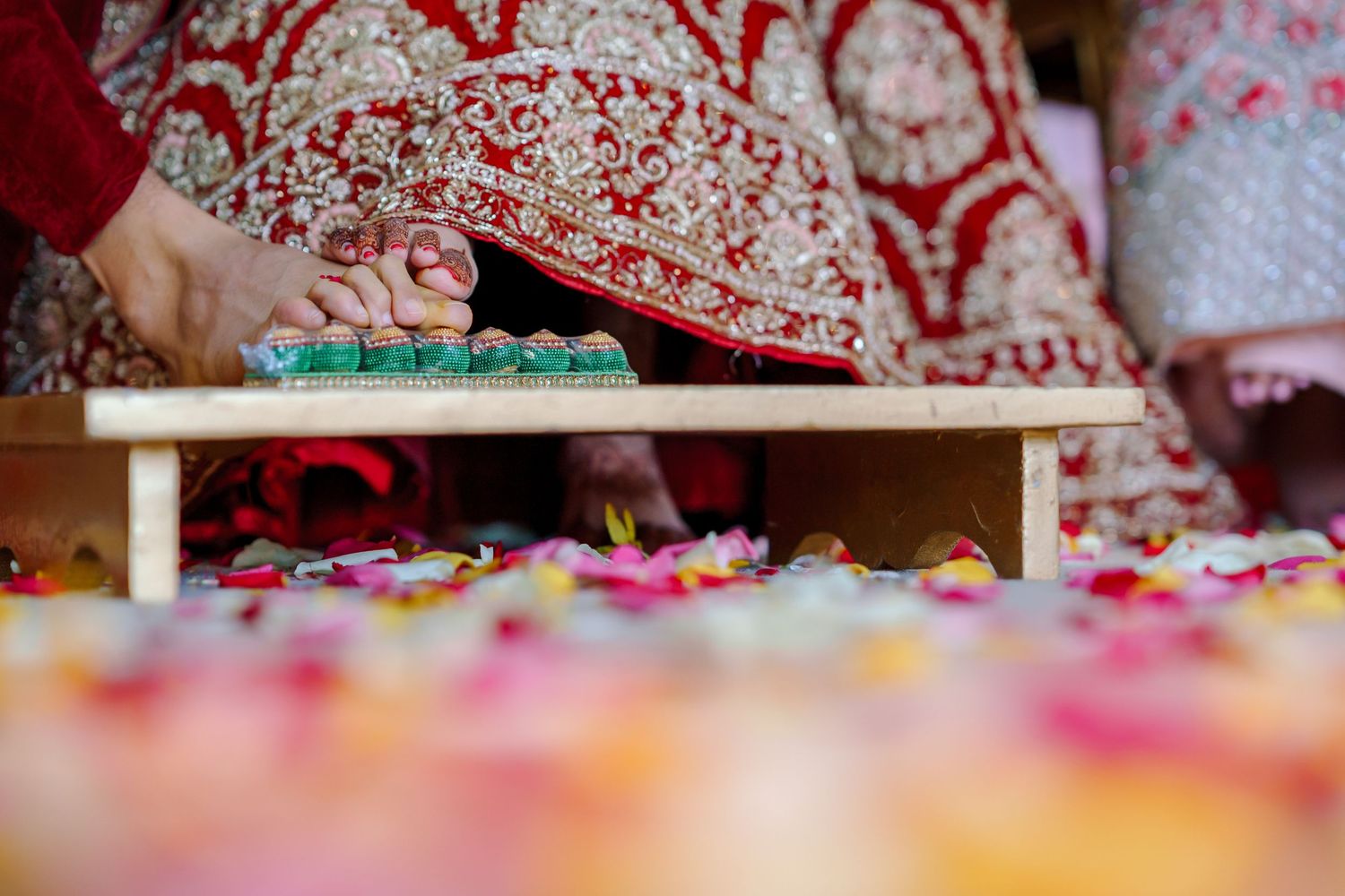 Detailed view of traditional Indian wedding decorations with rose petals and ceremonial items.