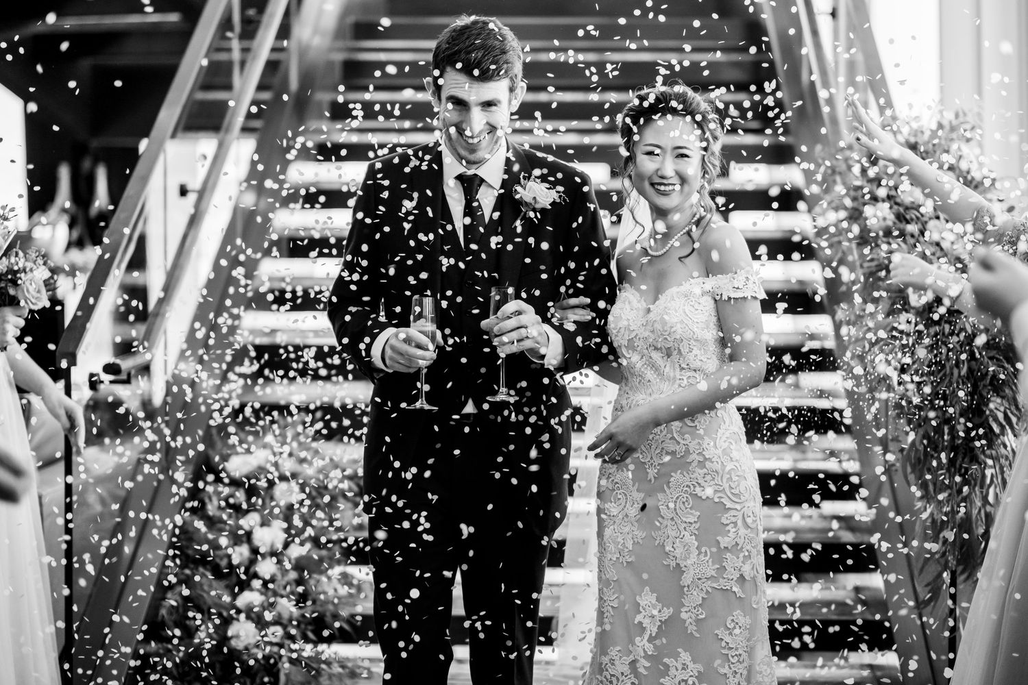 Wedding guests celebrate with confetti and bubbles during an outdoor ceremony.