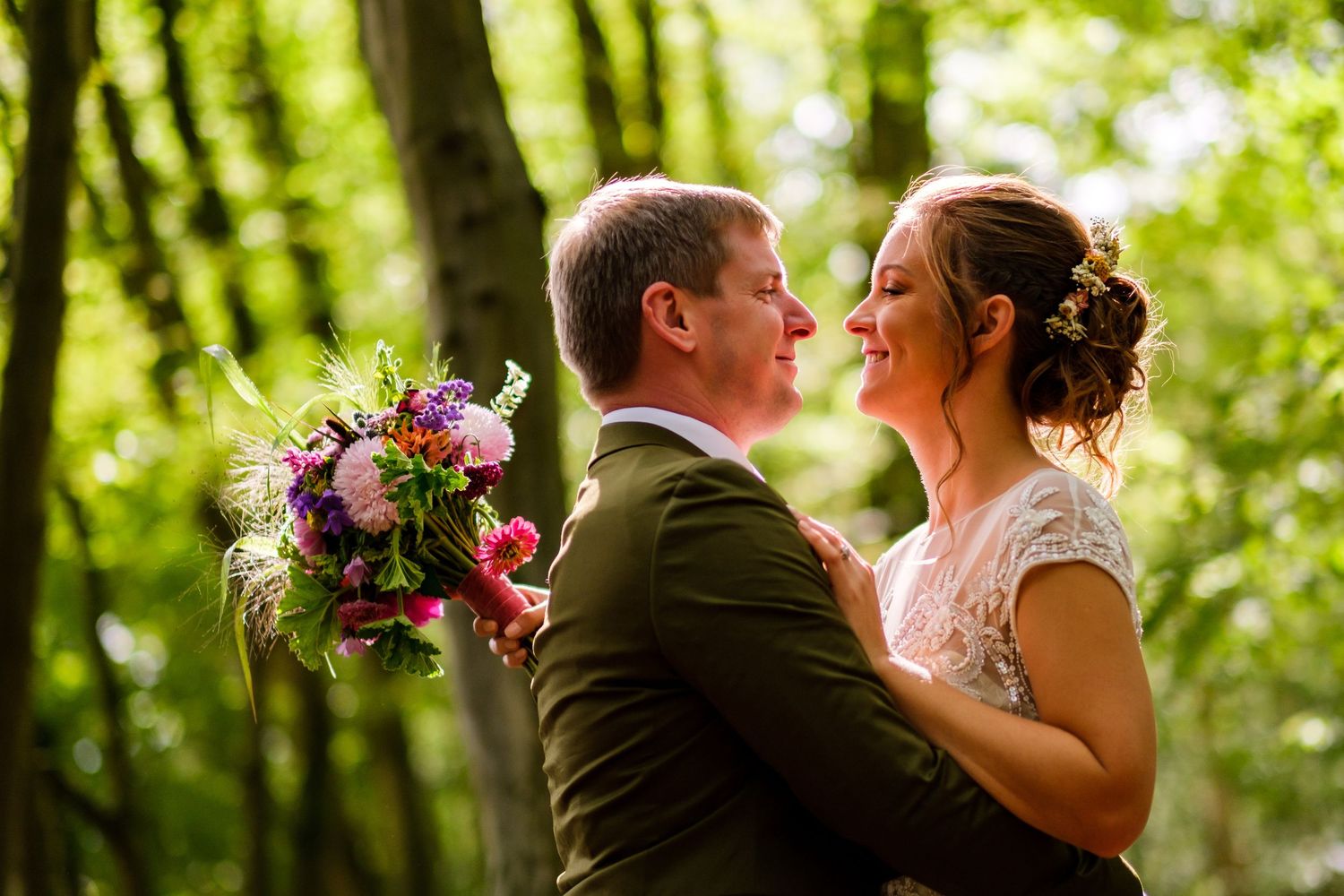 Romantic wedding moments captured in a lush green garden setting with pink floral bouquets.
