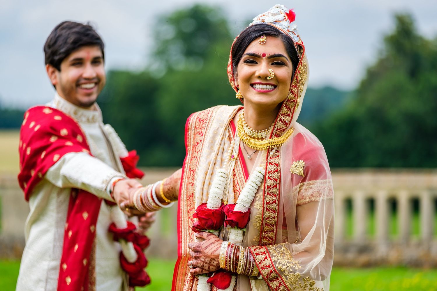 Traditional Indian wedding attire showcased in an outdoor portrait at a historic estate.