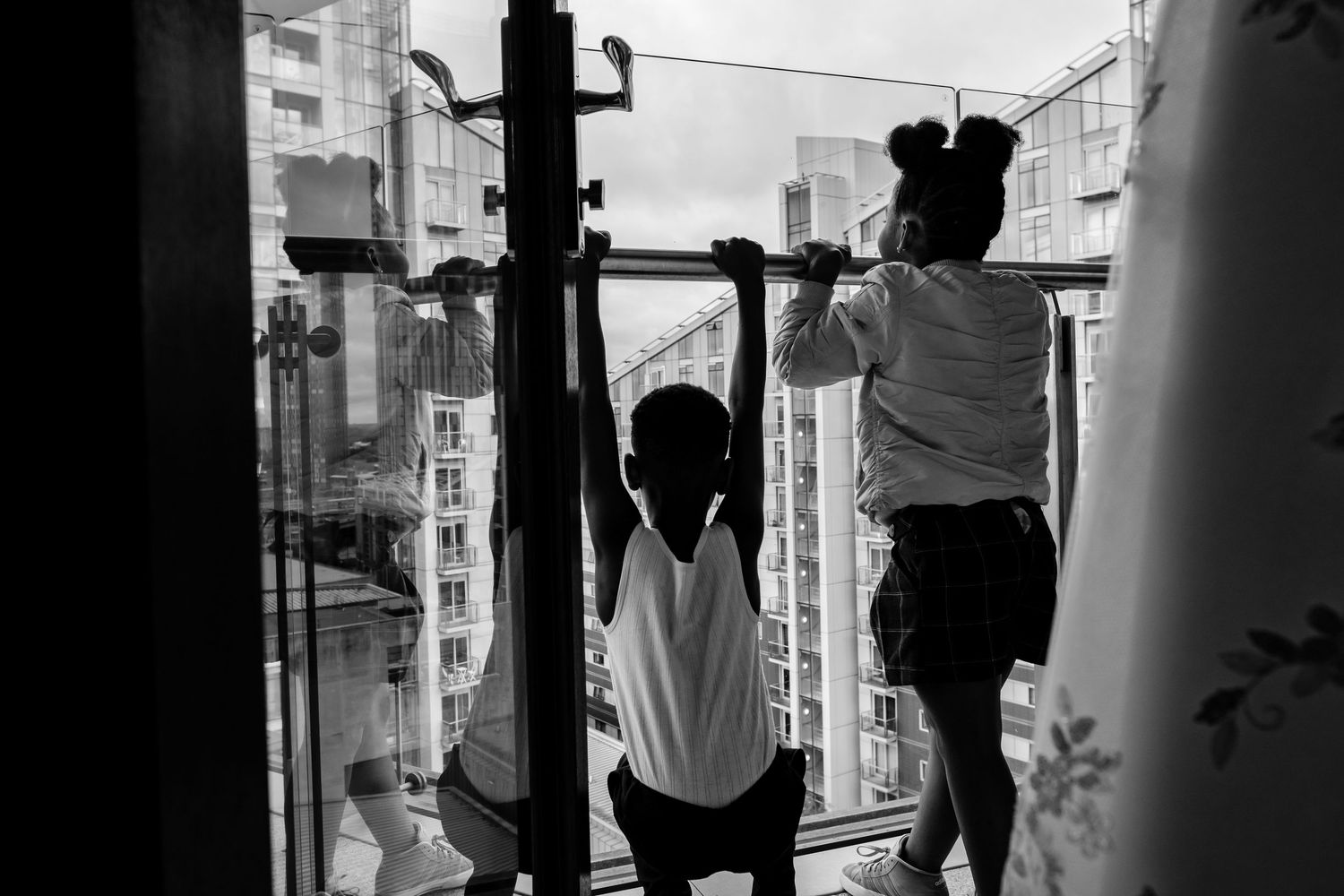 Silhouettes of people visible through windows in a modern apartment or office building.