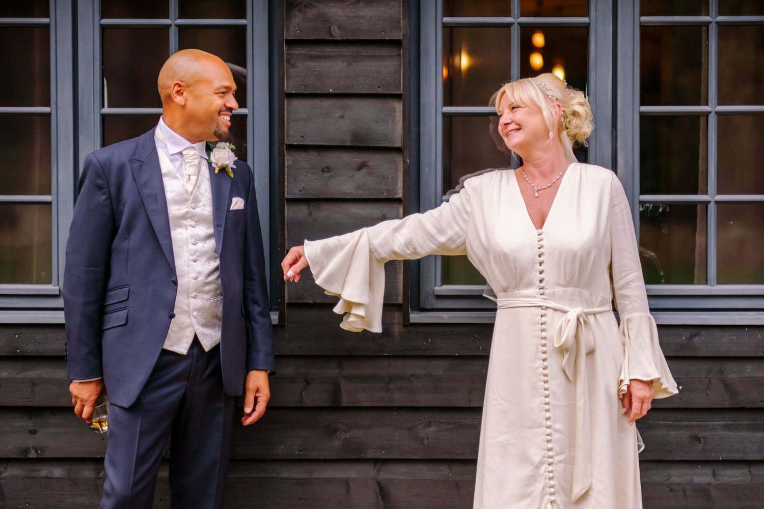 Dancing and celebration in an elegant room with dark wood paneling and windows.