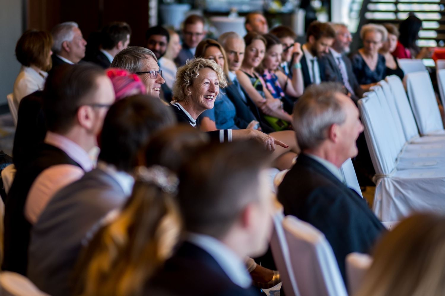 A crowded conference room filled with business professionals seated at tables during a corporate event or meeting.