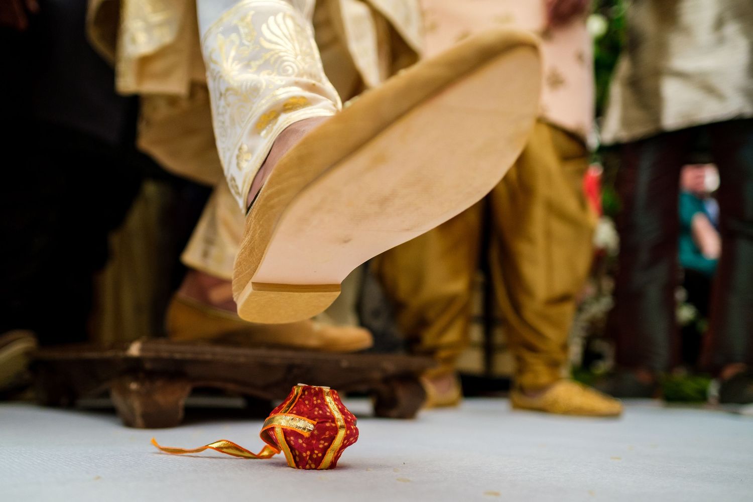 Wedding shoes and dress details shown against a church floor during a ceremony.