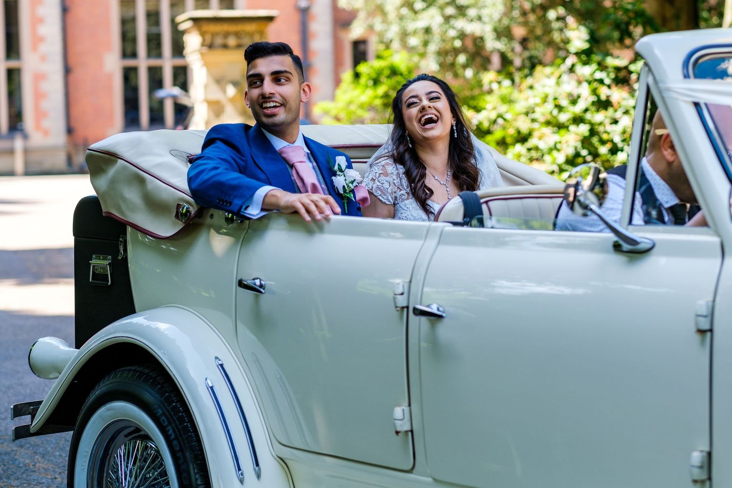 Classic white vintage car decorated for a wedding celebration with happy passengers.