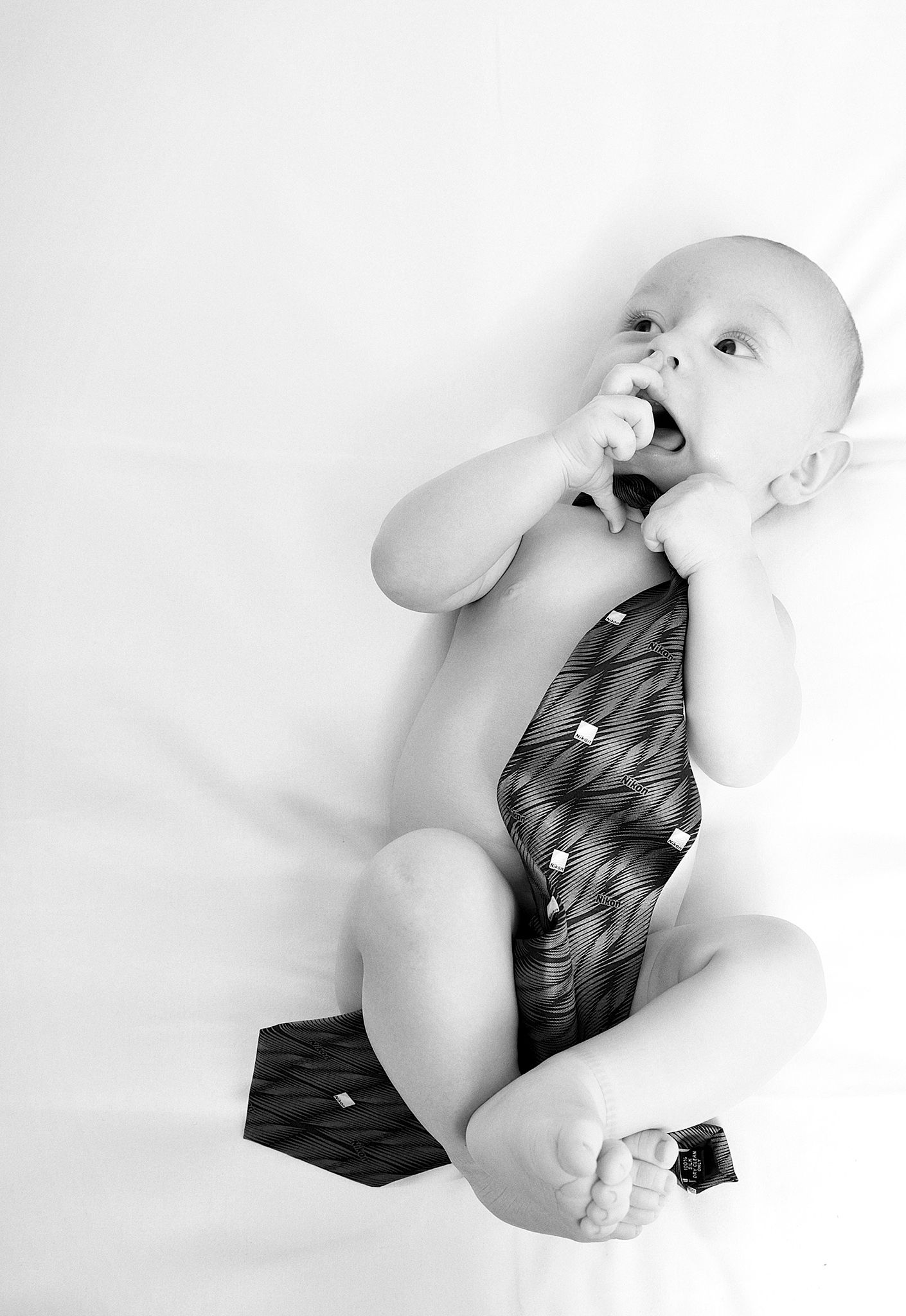 A series of artistic black and white baby portraits showing movement and emotion on white background.