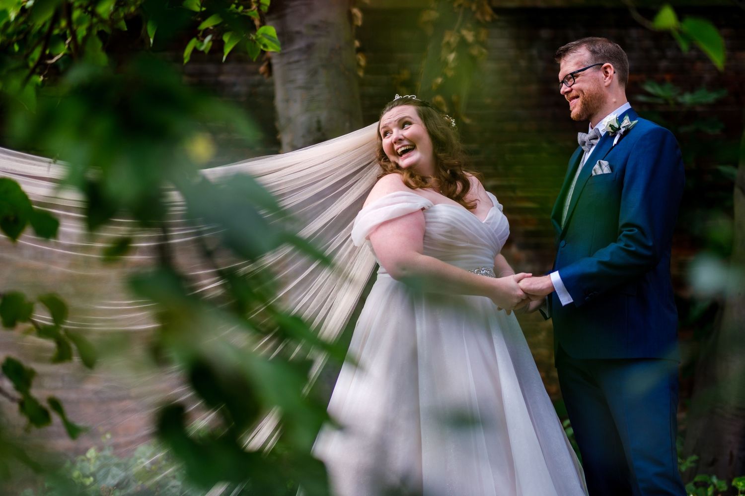 Wedding couple sharing an intimate dance moment outdoors surrounded by lush greenery.