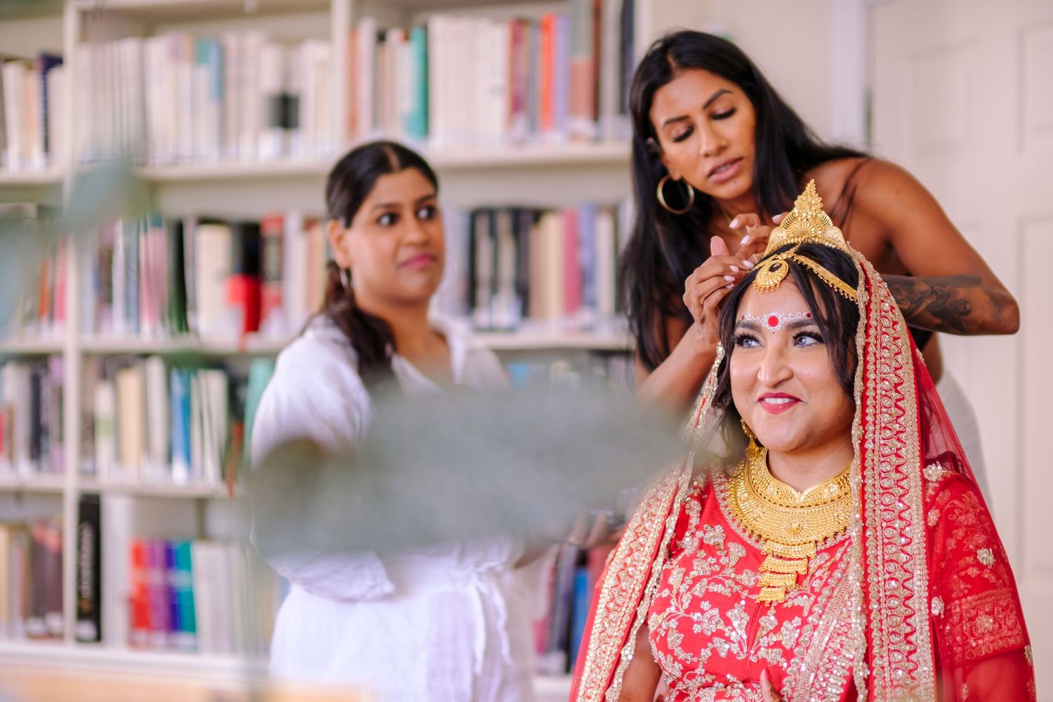 Group of people in traditional Indian attire gathering in a library setting.