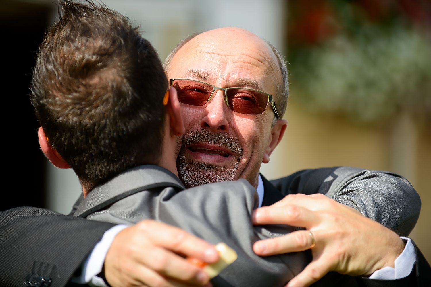 Emotional embrace between two people at formal celebration event.