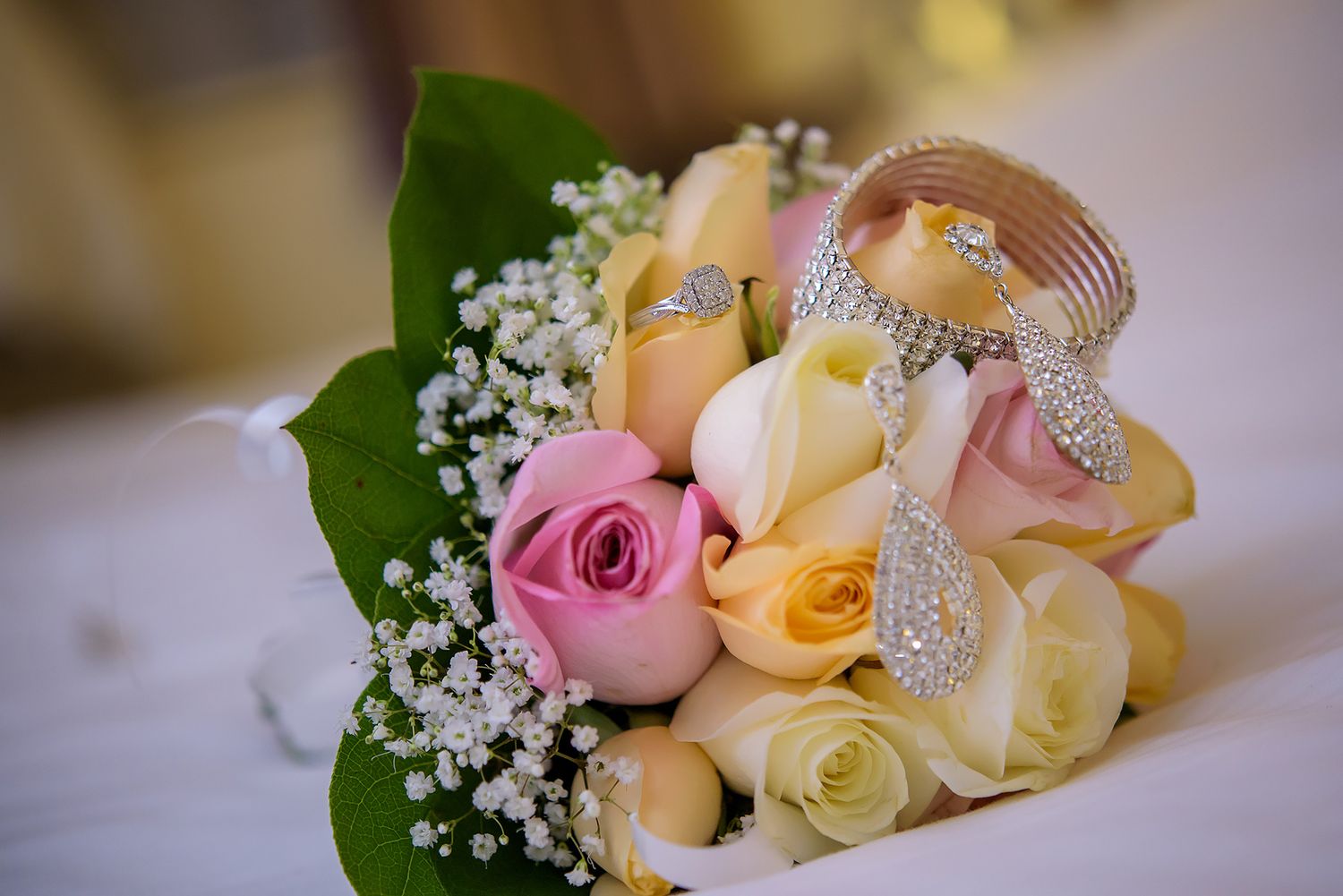 Delicate pink and cream roses with baby's breath arranged in romantic wedding bouquet.