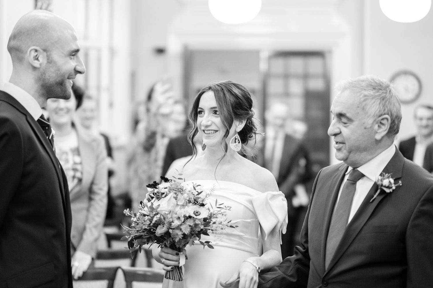 Wedding party candid moments captured in black and white during an indoor reception.