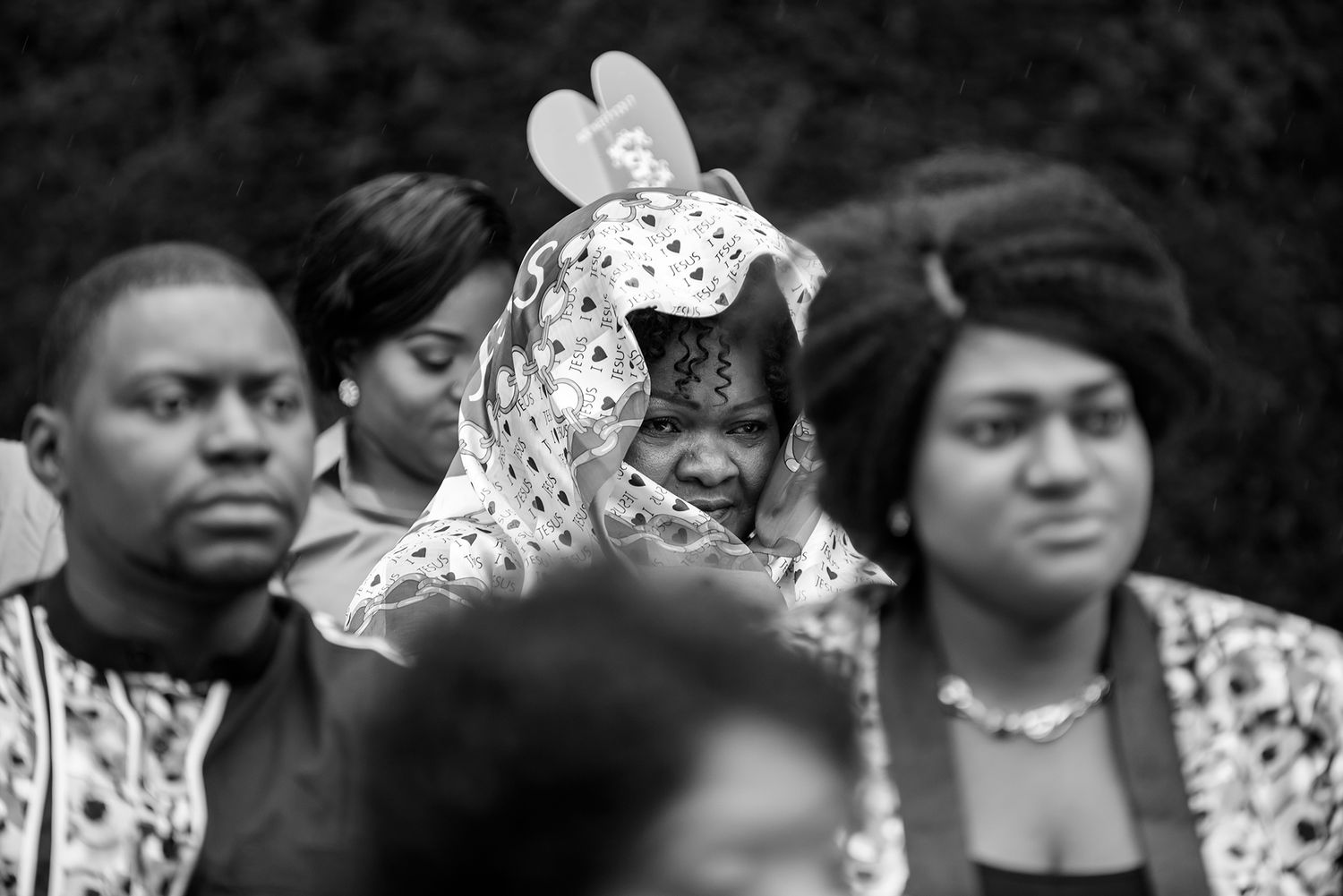 Wedding guests watching ceremony intently in formal attire.