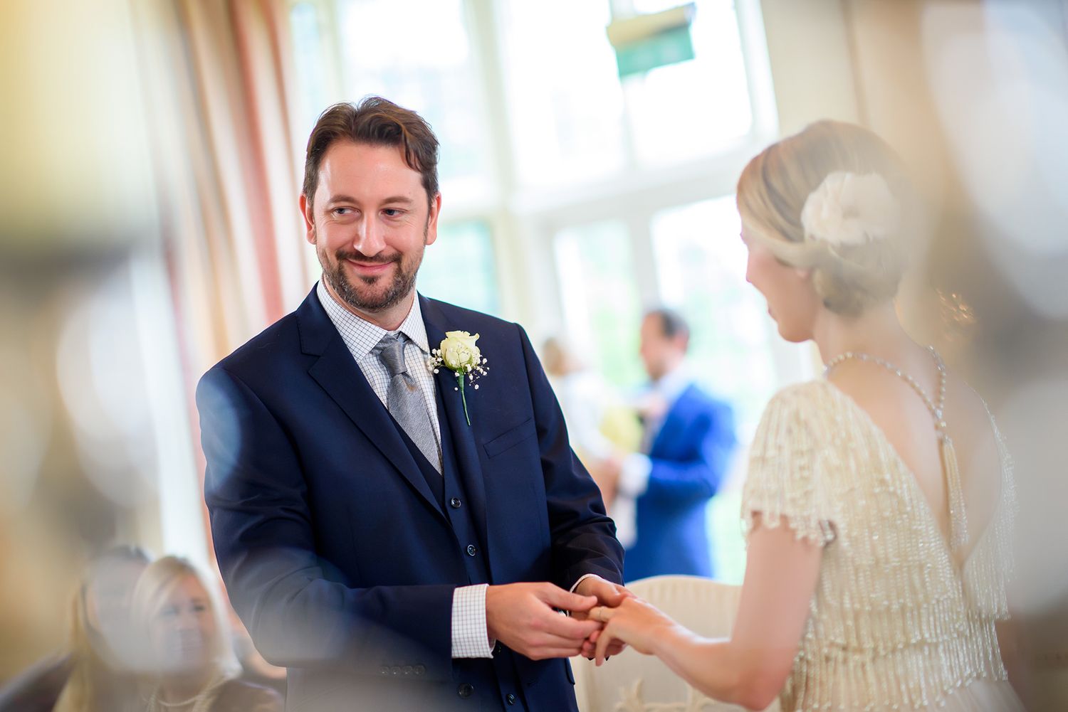 Intimate moment captured during wedding reception in bright formal setting.