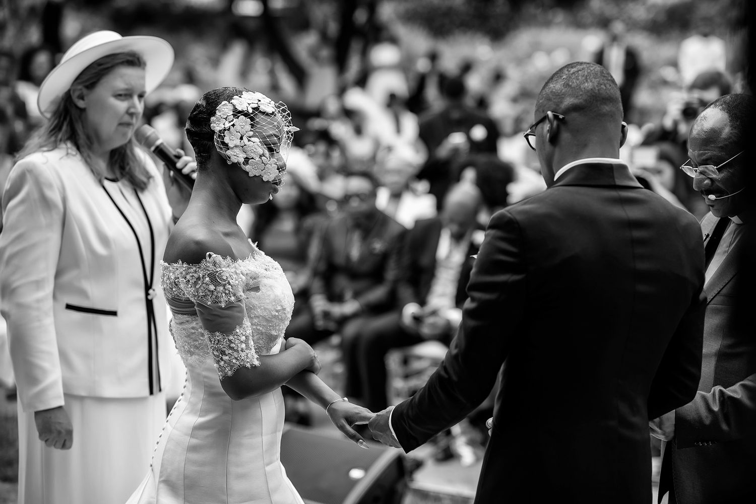 Black and white photo of wedding guests embracing during reception festivities.