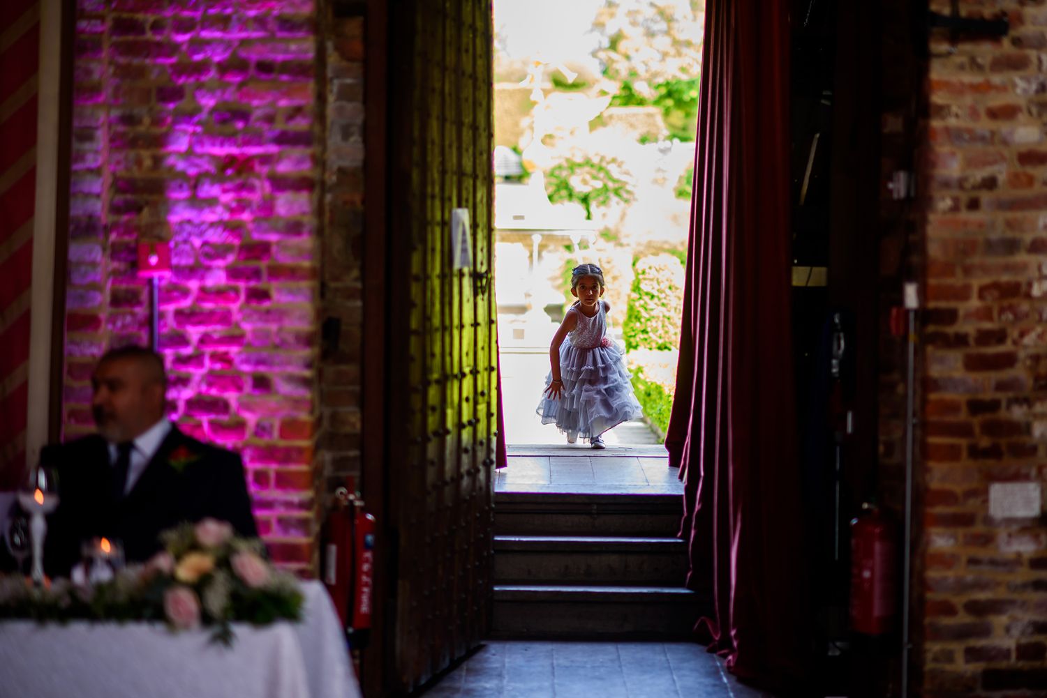 Historic venue interior with exposed brick walls illuminated by purple accent lighting.