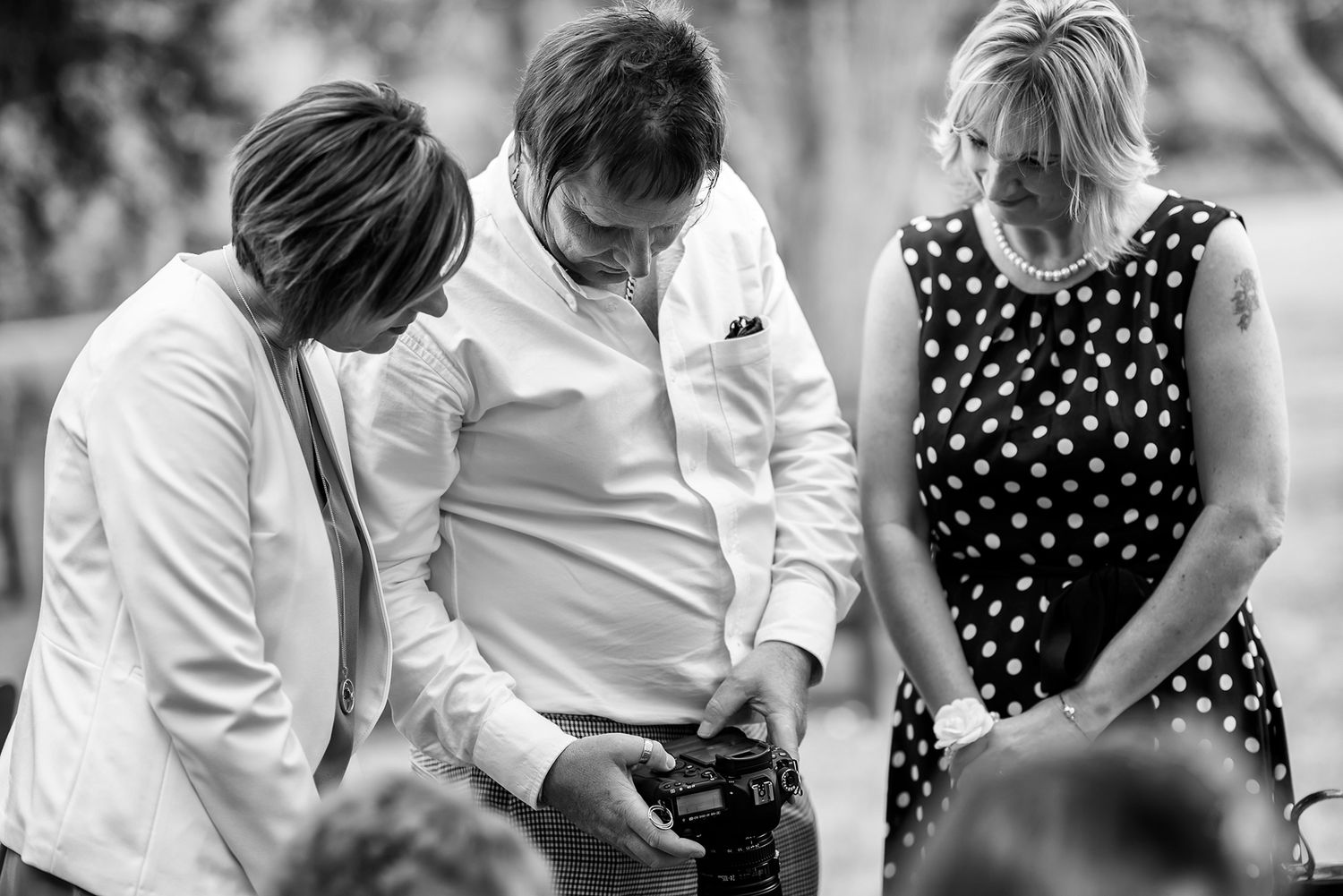 Black and white photo of guests dancing at a wedding reception.
