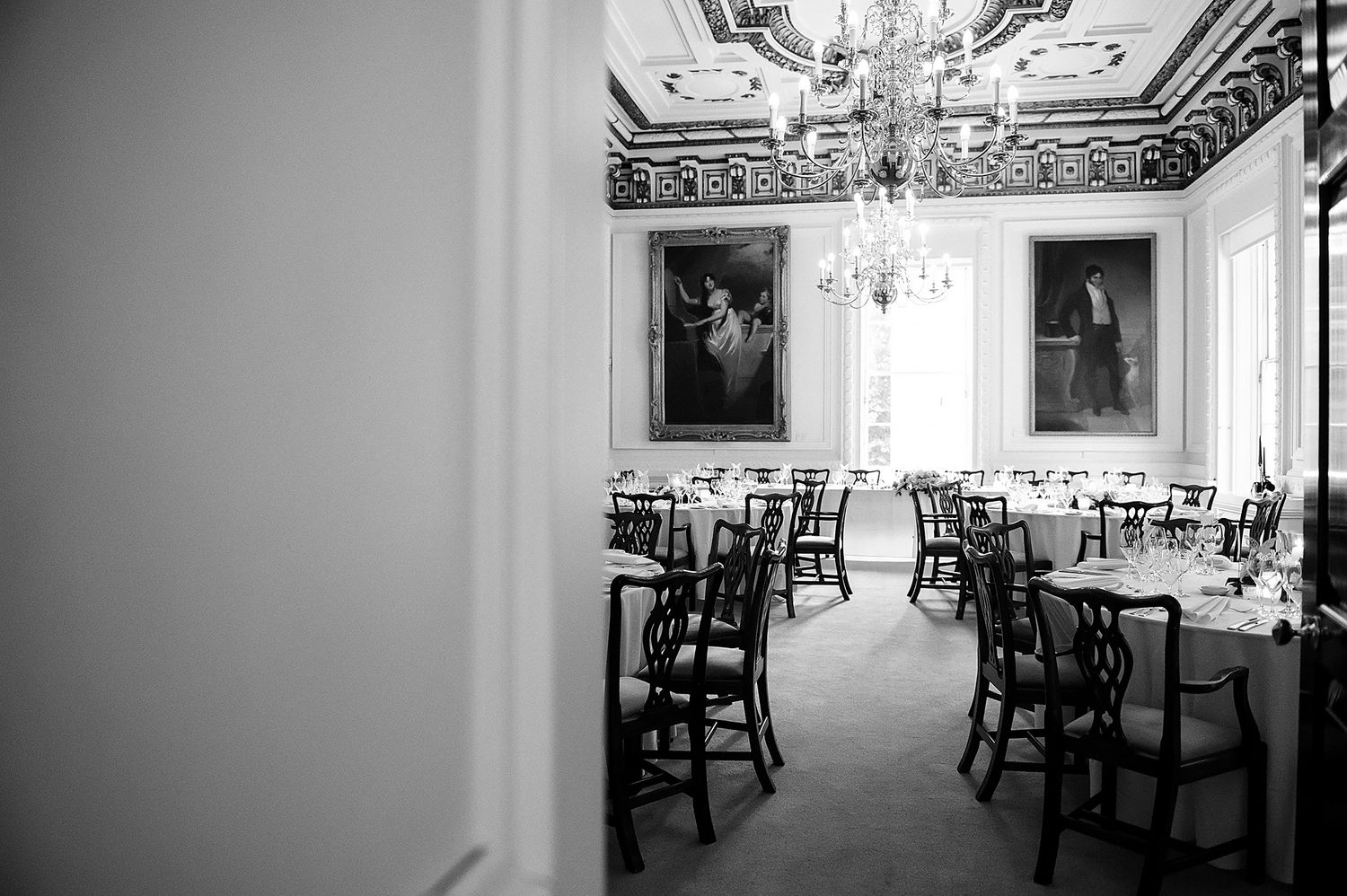 Elegant banquet hall interior with ornate ceiling details and formal table settings.