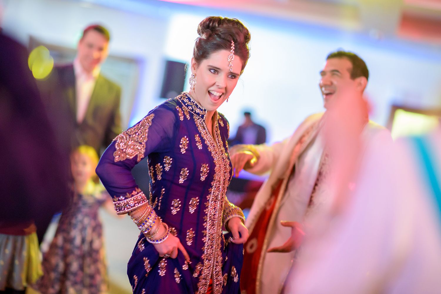 Wedding reception dance sequence with colorful lighting and festive atmosphere.
