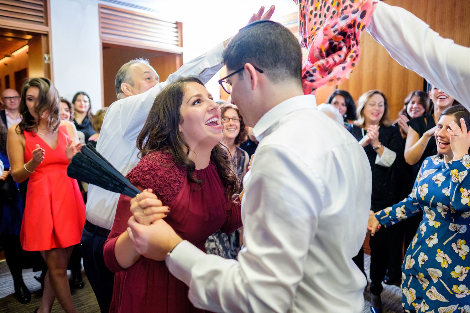 Celebration scene with guests dancing and enjoying themselves in a brightly lit indoor space.