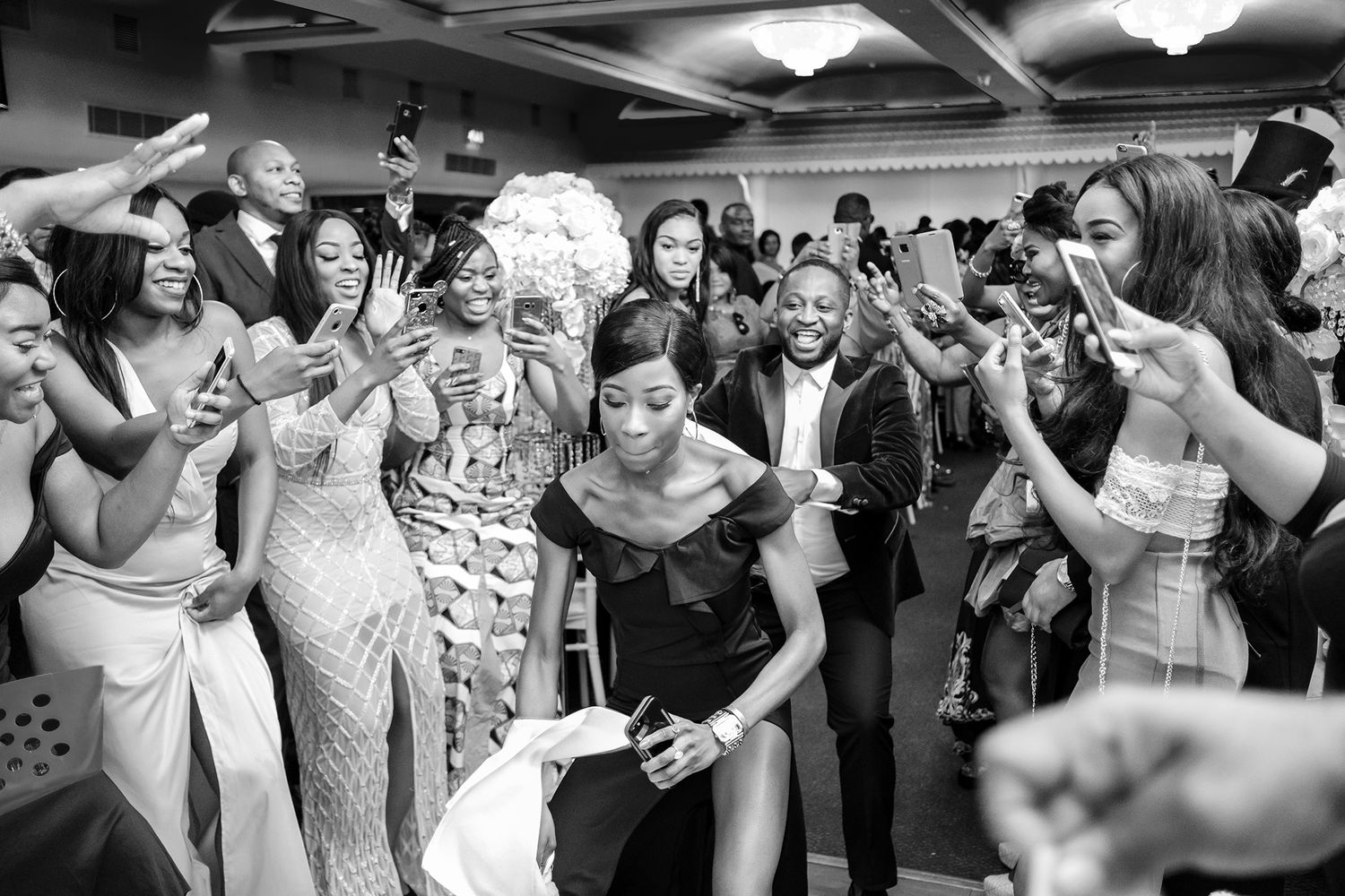 Black and white photo of wedding guests dancing and celebrating together.