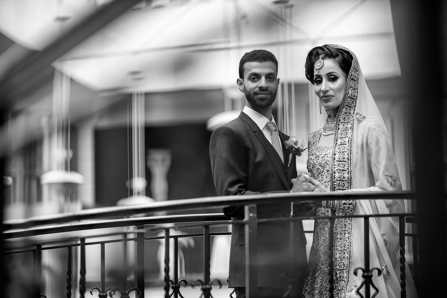 Black and white photograph of a wedding celebration in an elegant venue.
