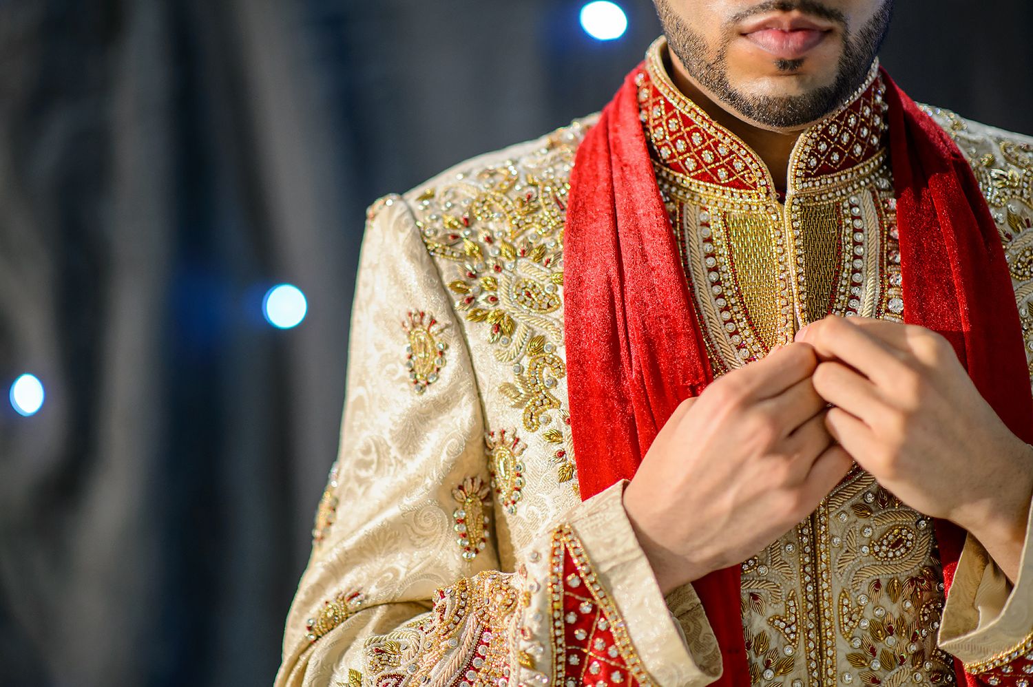 Details of traditional South Asian wedding attire with gold embroidery and red accents.