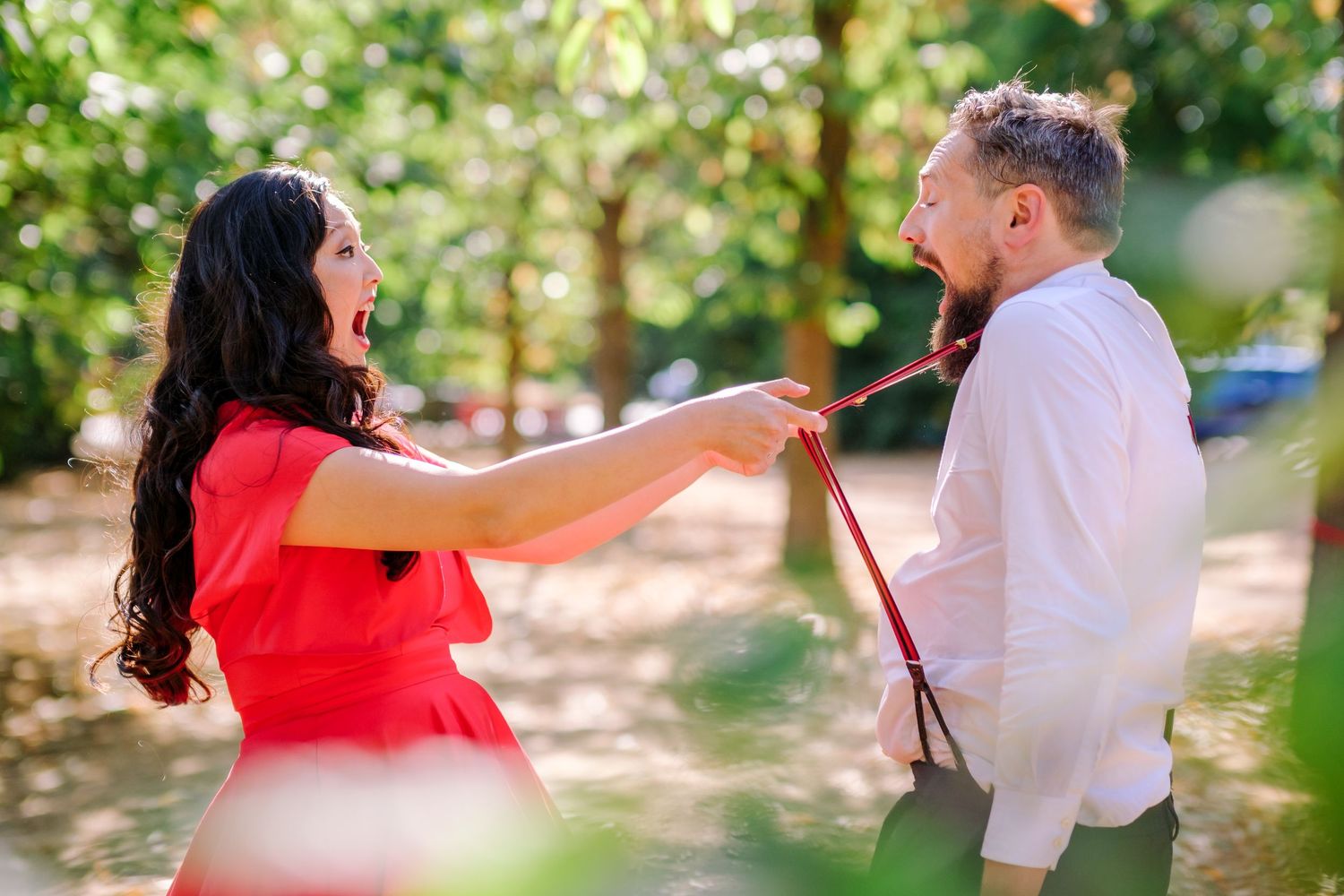Dancing couples twirl and spin in a sunny garden setting during a festive outdoor celebration.