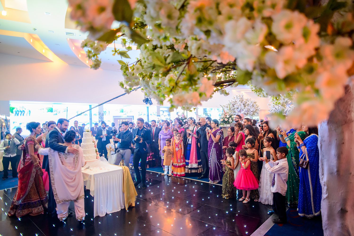 Wedding reception hall decorated with floral arrangements and soft ambient lighting.