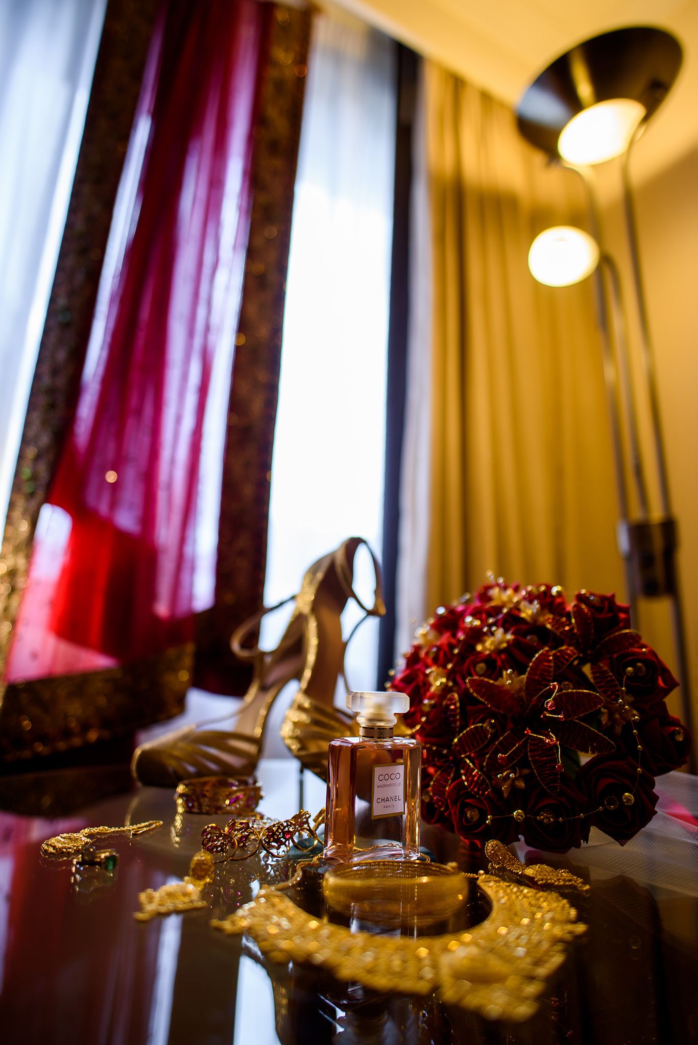 Wedding reception decor with burgundy curtains and elegant table settings.