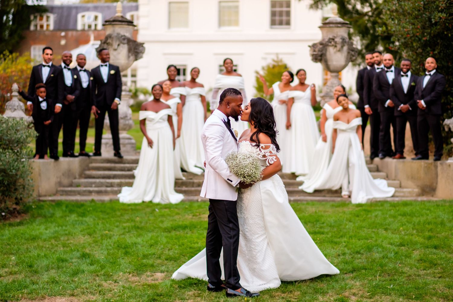 Candid wedding party photos on grassy lawn with classic architecture in background.