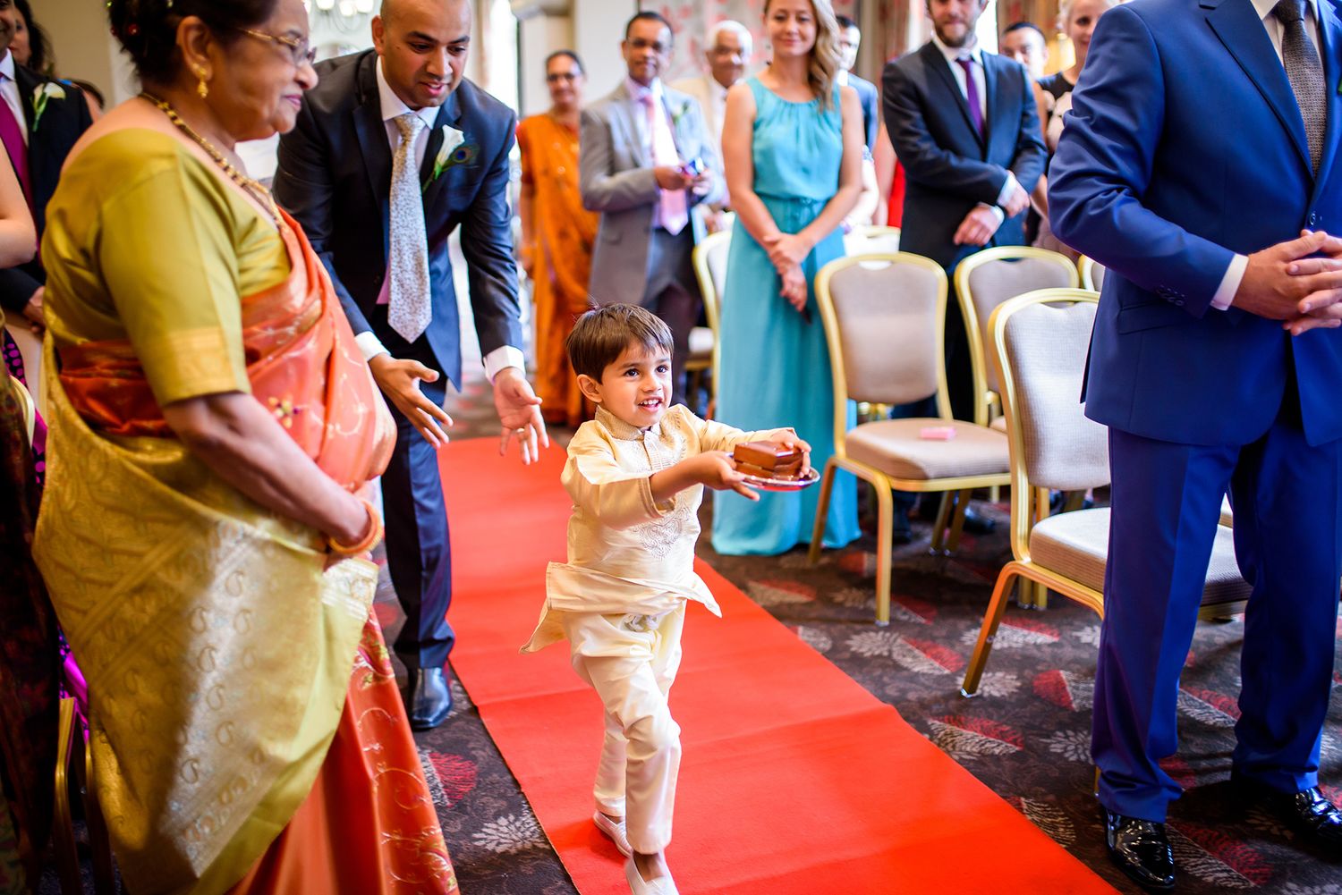 Wedding guests mingle and celebrate on a red carpet during the reception.