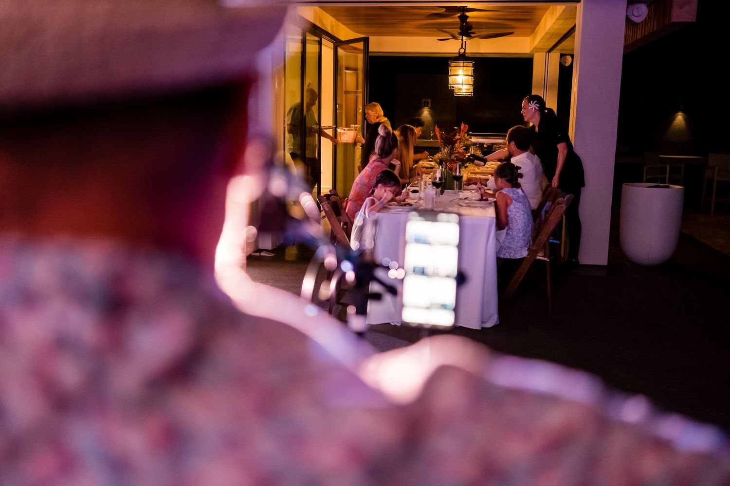 Wedding reception venue decorated with warm lighting and elegant table settings for evening celebration.
