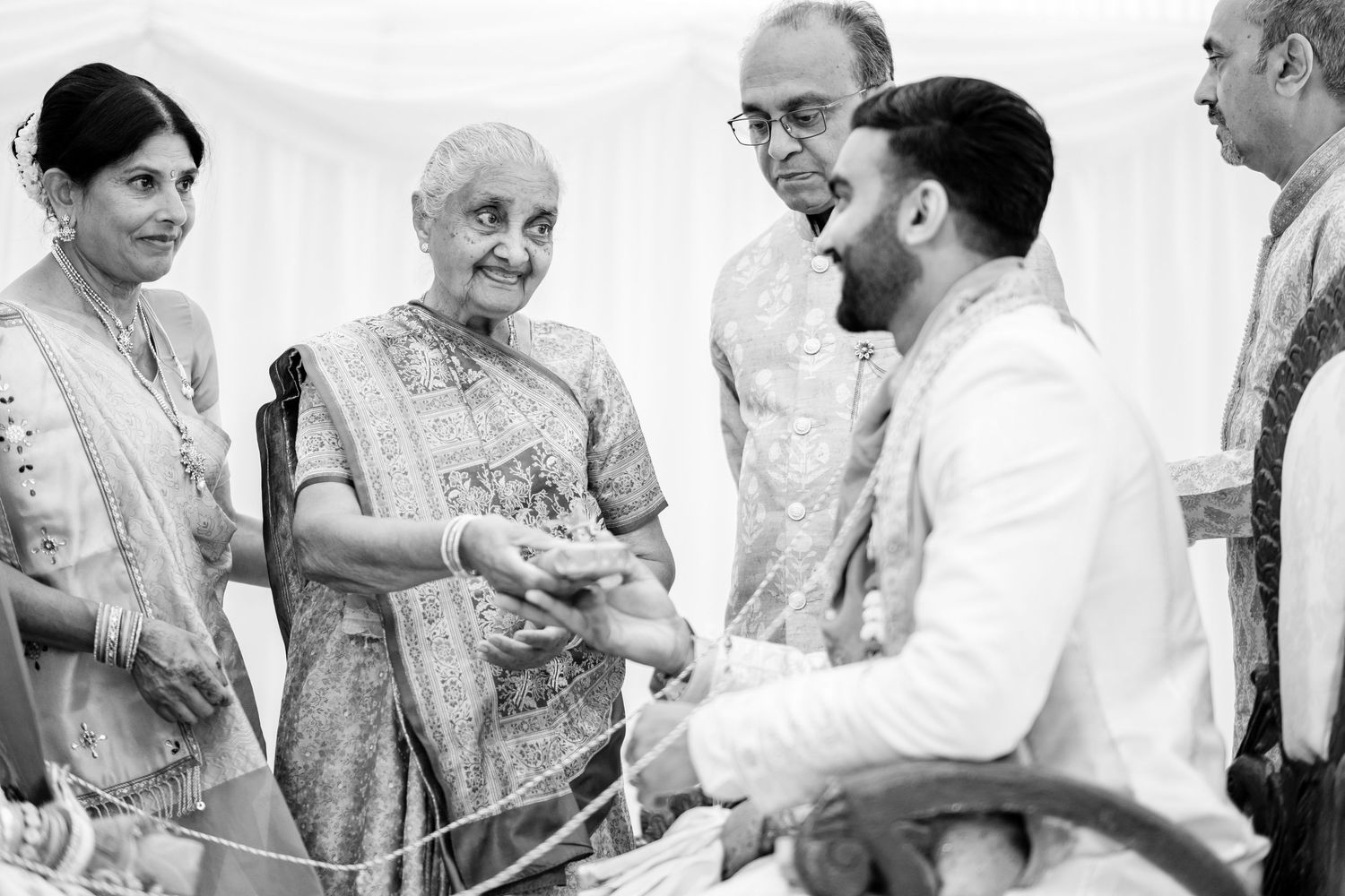 Black and white photo of traditional wedding ceremony interactions.